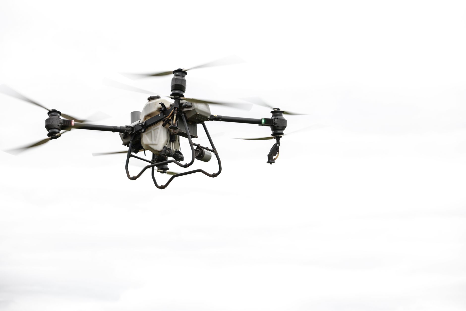 Drone agricole de haute technologie en vol sur un ciel nuageux, présentant la technologie agricole moderne.